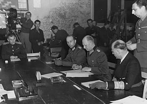 Generaloberst Alfred Jodl (Mitte), zuvor von Karl Dönitz dazu autorisiert, unterzeichnet die bedingungslose Kapitulation der Wehrmacht am 7. Mai 1945 in Reims. Foto: PD-USGov-Military-Army