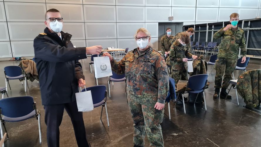 Hauptbootsmann Ebersbach (l.) und Hauptbootsmann Stern verteilen ein kleines Dankeschön an die engagierten Einsatzkräfte. Foto: DBwV/ Pietrzak