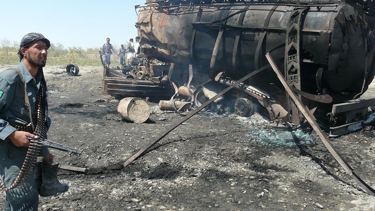 Ein Angehöriger der afghanischen Sicherheitskräfte inspiziert einen der völlig zerstörten Tanklaster. Foto: dpa