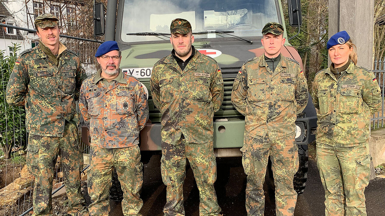 Die Sanitätssoldaten Oberfeldwebel Nick Thiele (l.), Hauptfeldwebel Michael von Ahlen (M.), Oberfeldwebel Lukas Stark (2.v.r.) und Stabsunteroffizier Anna Stupp erlebten einen dramatischen Einsatz in Erftstadt. Oberstabsfeldwebel Stefan Sprengers (2.v.l.) hat sie am Ort des Geschehens getroffen. Foto: DBwV/Frank Jungbluth