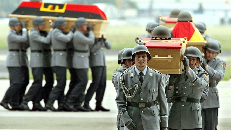 Bundeswehrsoldaten tragen am 10. Juni 2003 die vier Särge ihrer Kameraden auf dem Flughafen Köln-Wahn zu einer Flughalle, in der die Gedenkfeier stattfand. Die sterblichen Überreste der in Kabul bei einem Terroranschlag getöteten Soldaten waren zuvor mit einem Airbus der Luftwaffe nach Deutschland gebracht worden. Foto: dpa