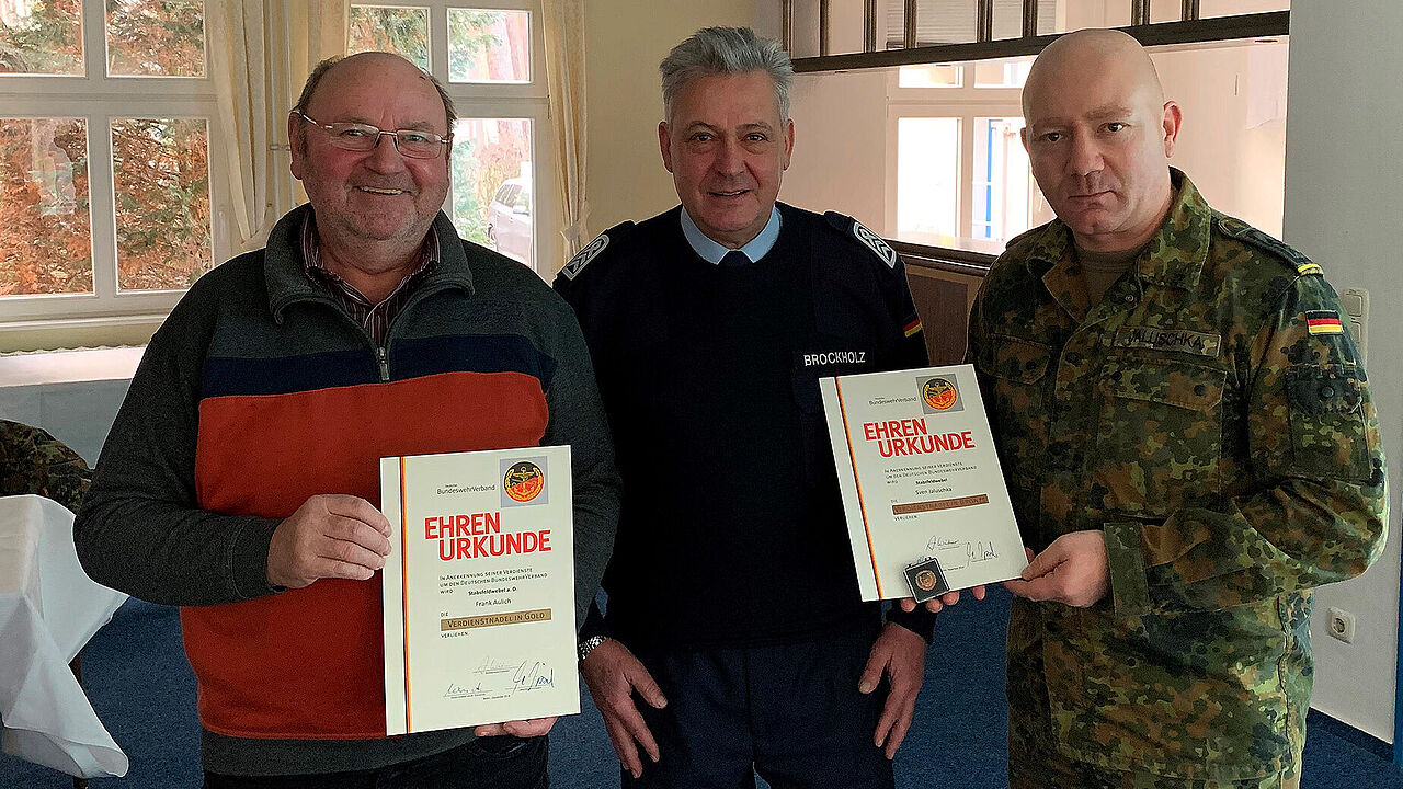 OStFw a.D. Brockholz (m) übergibt die Ehrenurkunden an StFw a.D. Aulich (l) und StFw Jaluschka (r). Foto: DBwV/ Giesecke