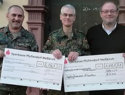 Oberst Jochen Gumprich (Mitte) übergibt die Spendenschecks in Höhe von jeweils 1.181,71 Euro an Pfarrer Markus Manter (r.) für den Orgelbauförderverein. Für die Soldaten und Veteranen Stiftung nahm Oberstleutnant Josef Rauch, der stellvertretende Vorsitzende des Landesverbandes Süddeutschland, den Scheck entgegen. Foto: SVS