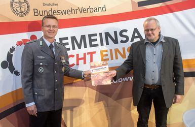 Tobias Pflüger (Die Linke) nimmt das Forderungspapier des DBwV entgegen. Foto: DBwV/Yann Bombeke