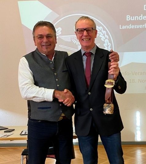 Bezirksvorsitzender Franz Jung bedankt sich beim ERH-Vorsitzenden Albrecht Kiesner mit einer für das Allgäu typischen Schumpenschelle. Foto: Michael Lipp