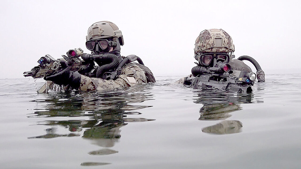 Kampfschwimmer vom Kommando Spezialkräfte der Marine (KSM) gehen mit G36 Sturmgewehren bei einer Übung aus der Ostsee an Land. Foto: Carsten Rehder/dpa
