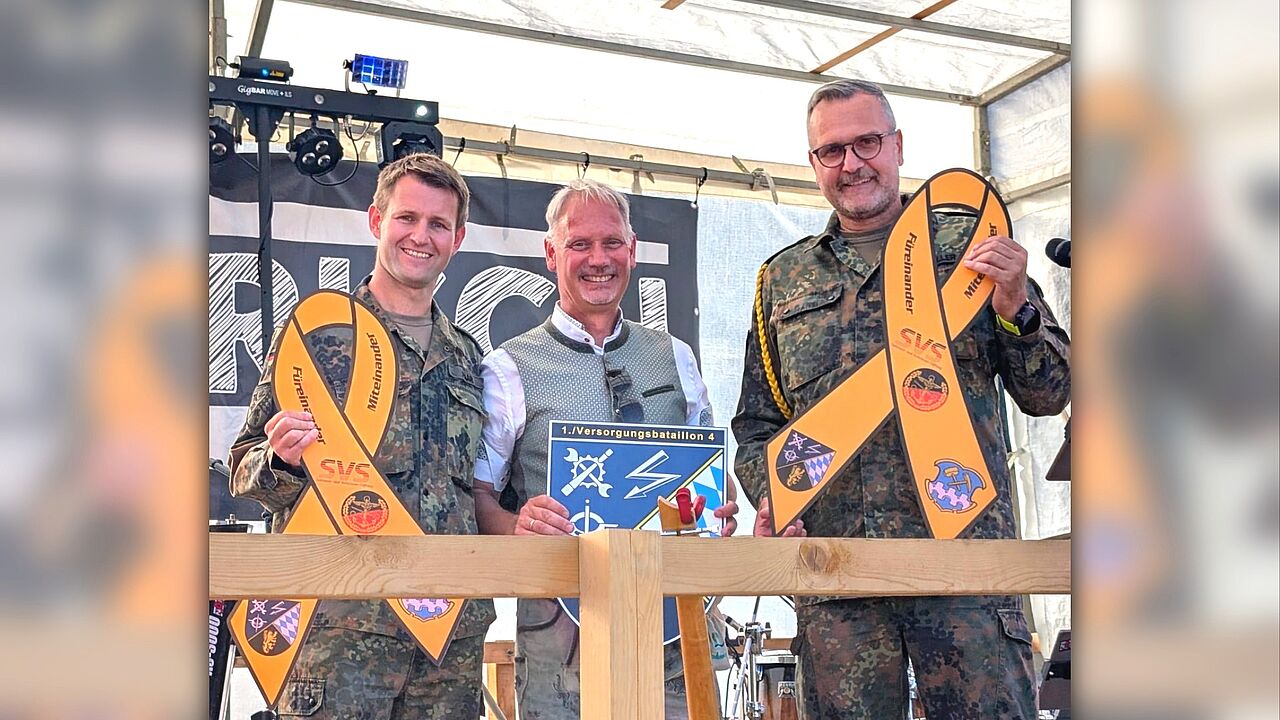 Ein sichtbares Zeichen der Verbundenheit: Kompaniechef Major Kevin H. (von links), Bürgermeister Georg Hoffmann und Kompaniefeldwebel Oberstabsfeldwebel Tobias M. nach der Übergabe der Gelben Schleife und des Kompaniewappens. Foto: tm