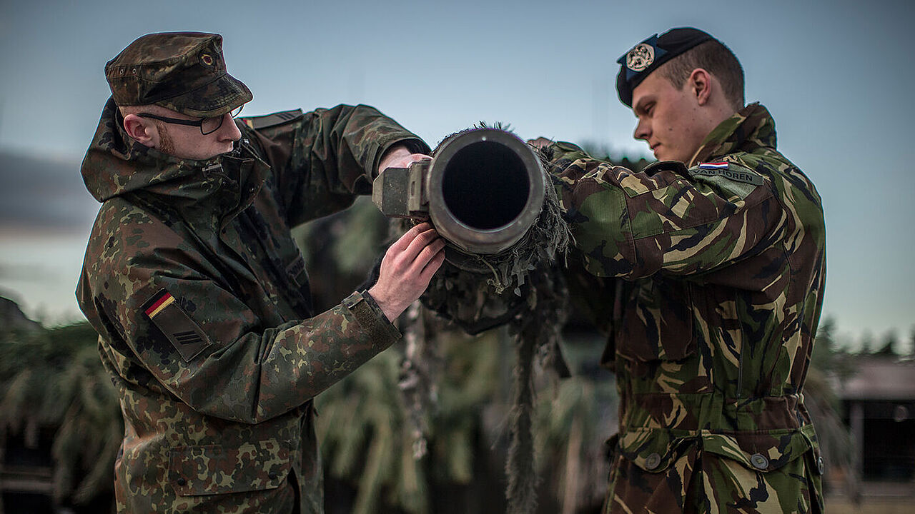 Ein Kampfpanzer des binationalen Panzerbataillons 414 wird von einem deutschen und einem niederländischen Soldaten für den Einsatz vorbereitet.