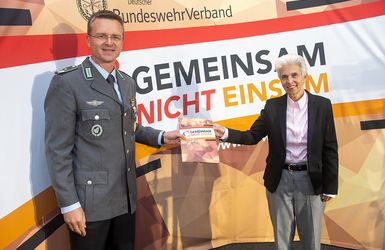 Oberstleutnant André Wüstner übergibt das Forderungspapier an die FDP-Verteidigungsexpertin Marie-Agnes Strack-Zimmermann. Foto: DBwV/Yann Bombeke