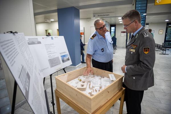 An einem Modell erläuterte Generalarzt Jens Diehm dem Bundesvorsitzenden die im Bau befindliche Erweiterung des Bundeswehrzentralkrankenhauses. Foto: DBwV/Yann Bombeke