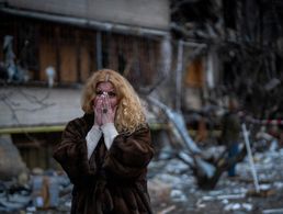 Fassungslos steht eine Ukrainerin vor den Trümmern eines Wohnblocks in Kiew, der in der Nacht bei einem russischen Raketenangriff zerstört wurde. picture alliance / ASSOCIATED PRESS / Emilio Morenatti