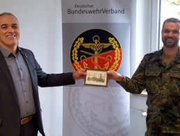 Hauptmann Bernd Link (r.) bedankte sich beim Ersten Stellvertretenden Bundesvorsitzenden mit einer Radierung des Veitshöchheimer Rokokogartens. Foto: DBwV/Roland Stengl