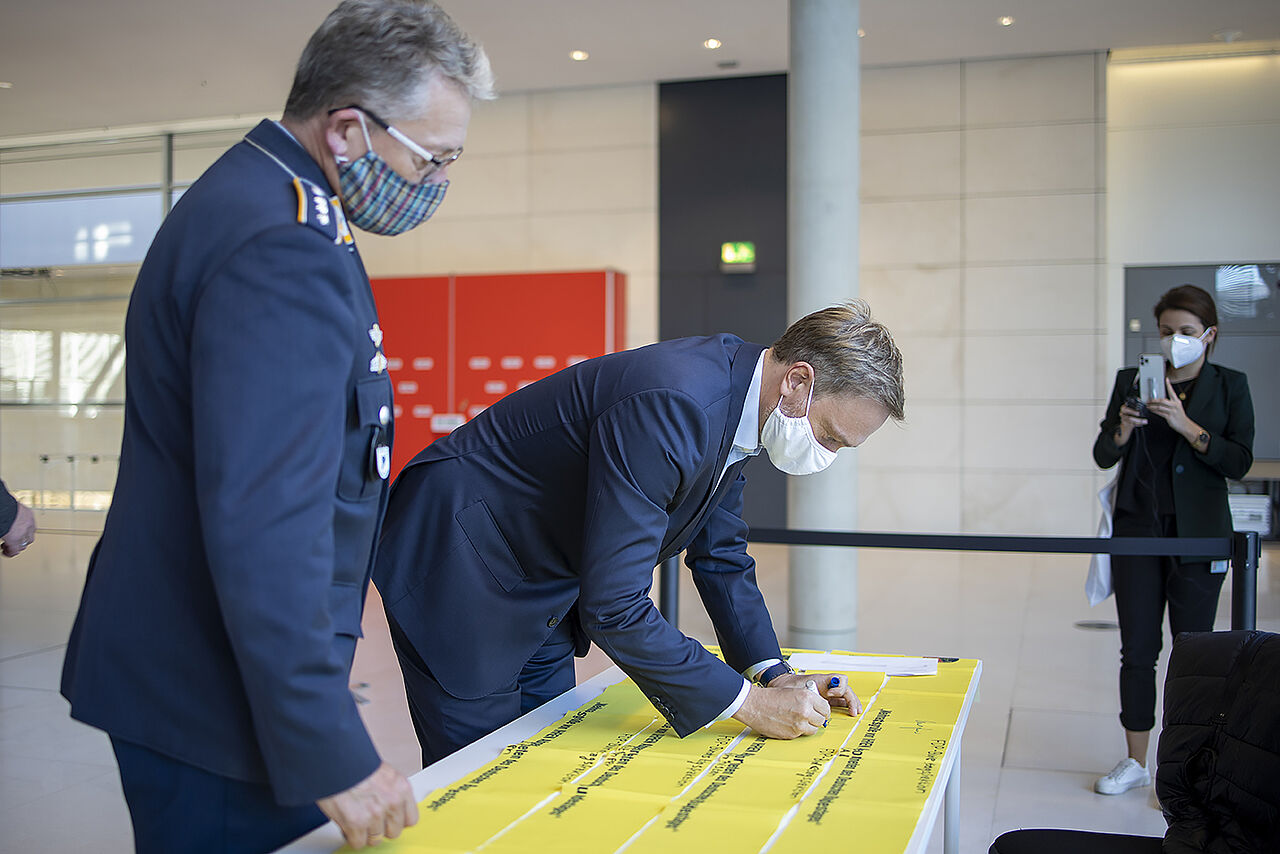 Der FDP-Vorsitzende Christian Lindner unterschreibt ein Gelbes Band. Foto: DBwV/Yann Bombeke
