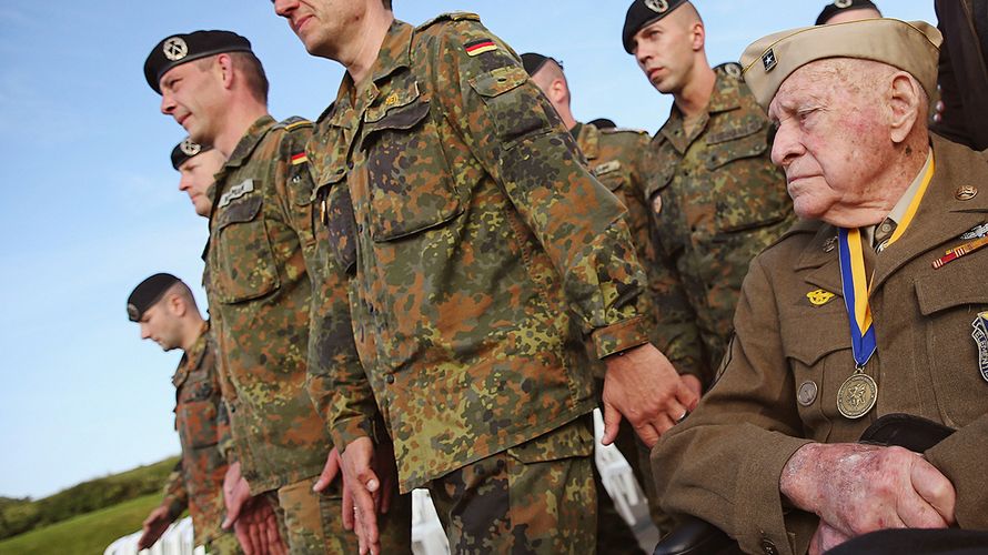 Deutsche Soldaten neben einem Veteran des Zweiten Weltkriegs bei den Gedenkfeiern zum 70. Jahrestag der Invasion in der Normandie (D-Day). Unterschiedliche Kulturen prägen den Umgang mit Veteranen. Foto: getty images