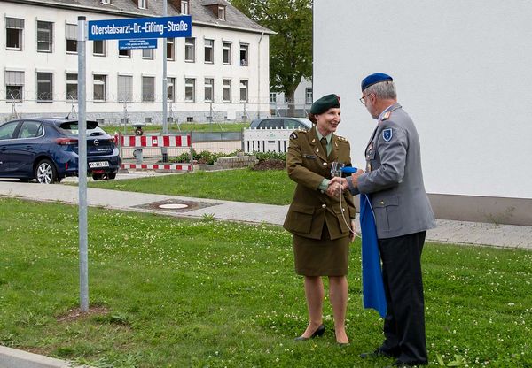 Generaloberstabsarzt Dr. Ulrich Baumgärtner, enthüllt gemeinsam mit der eigens aus Neuseeland angereisten Witwe des Namenspatrons das Straßenschild der Oberstabsarzt-Dr.-Eißing-Straße vor dem Sanitätsversorgungszentrum Koblenz. Bundeswehr/Michael Laymann