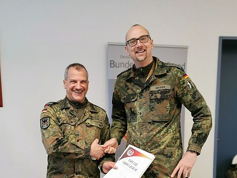 Ehrung für 25 Jahre Mitgliedschaft. Hauptmann Christian Weber überreicht Oberstleutnant Christian Wolf die Treueurkunde für 25 Jahre Mitgliedschaft im DBwV. Foto: Rene Ron Hinz