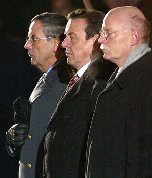 Bundeskanzler Gerhard Schröder (SPD, M.), Bundesverteidigungsminister Peter Struck (SPD, r.) und Generalinspekteur der Bundeswehr, General Wolfgang Schneiderhan (l.) beim Großen Zapfenstreich auf dem Rathausplatz in Hannover 2005.