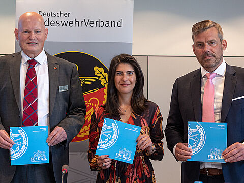 (v.l.n.r.) Klaus-Hermann Scharf (Vorsitzender des Fachbereichs Zivile Beschäftigte), Serap Güler (CDU/CSU-Bundestagsfraktion) und Oberstleutnant der Luftwaffe Falko Droßmann (SPD- Bundestagsfraktion) halten die Broschüre "Bundeswehr in Zivil #WirGestaltenUnserMorgen" in den Händen. Foto: DBwV/Sarina Flachsmeier