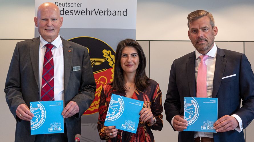 (v.l.n.r.) Klaus-Hermann Scharf (Vorsitzender des Fachbereichs Zivile Beschäftigte), Serap Güler (CDU/CSU-Bundestagsfraktion) und Oberstleutnant der Luftwaffe Falko Droßmann (SPD- Bundestagsfraktion) halten die Broschüre "Bundeswehr in Zivil #WirGestaltenUnserMorgen" in den Händen. Foto: DBwV/Sarina Flachsmeier