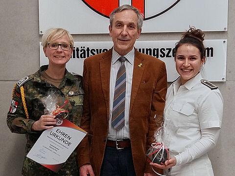 Die bisherige Vorsitzende Stabsfeldwebel Melanie Penz (l.) mit Landesvorsitzendem Gerhard Stärk übergibt den Staffelstab an ihre Nachfolgerin Feldwebel Rebecca Satzger. Foto: TruKa Sanität Müllheim