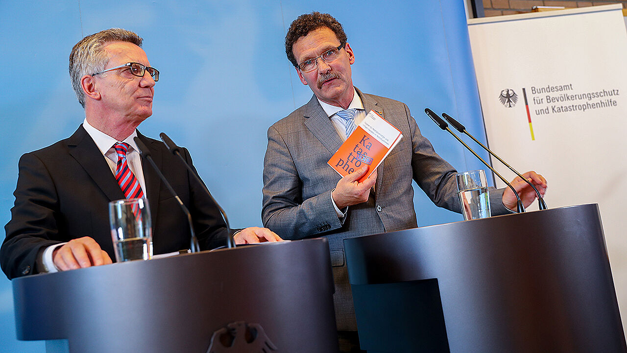Bundesinnenminister Thomas de Maizière (l.) und der Präsident des Bundesamtes für Bevölkerungsschutz und Katastrophenhilfe, Christoph Unger präsentieren die Konzeption für Zivile Verteidigung im Berliner Wasserwerk Tegel. Foto: dpa