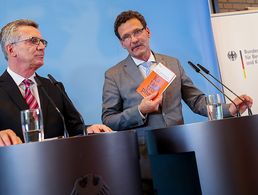Bundesinnenminister Thomas de Maizière (l.) und der Präsident des Bundesamtes für Bevölkerungsschutz und Katastrophenhilfe, Christoph Unger präsentieren die Konzeption für Zivile Verteidigung im Berliner Wasserwerk Tegel. Foto: dpa