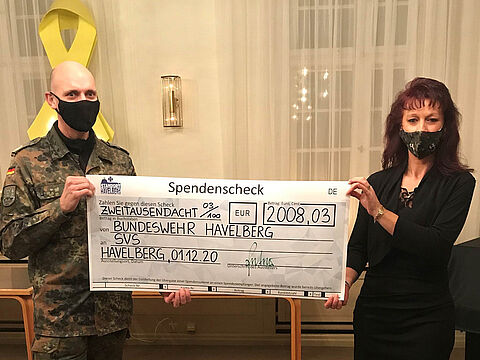 Oberstleutnant Ralph Peter, Kommandeur Panzerpionierbataillon 803, übergibt den Spendenscheck an SVS-Mitarbeiterin Katrin van Treek. Foto: Bundeswehr