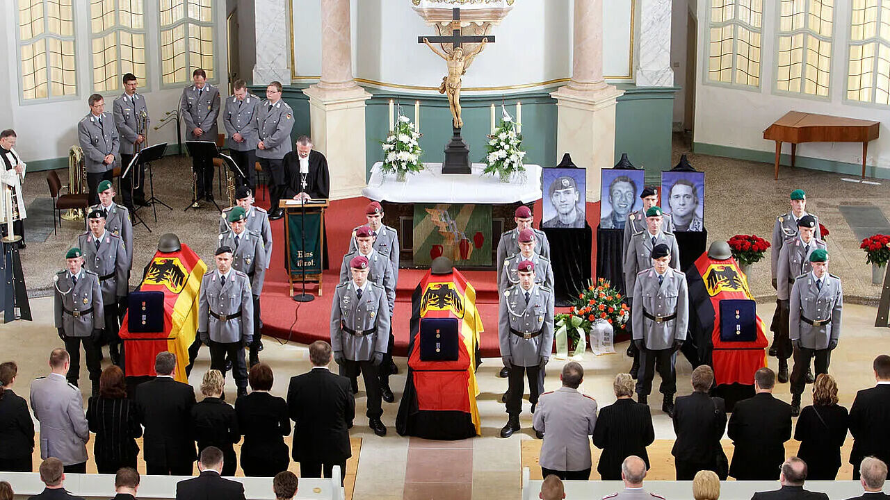 Trauer-Gottesdienst in Bad Salzungen 2009: Hinter den Särgen der Hauptgefreiten Martin Brunn (r.), Alexander Schleiernick (M.) und Oleg Meiling (l.) stehen Bilder der Soldaten. Foto: dpa 