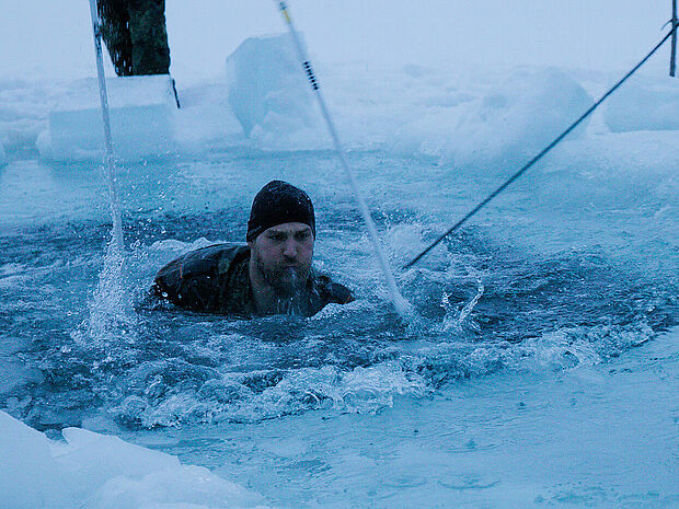 Beim Eissprung: Ein Gebirgsjäger kämpft sich durch das eiskalte Wasser. Foto: Bundeswehr/Skinner