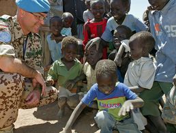 Symbolbild: Ein Oberstleutnant unterhält sich im April 2006 mit Flüchtlingskindern im Binnenflüchtlingslager Jebel Aulia. Foto: Bundeswehr/Rott 