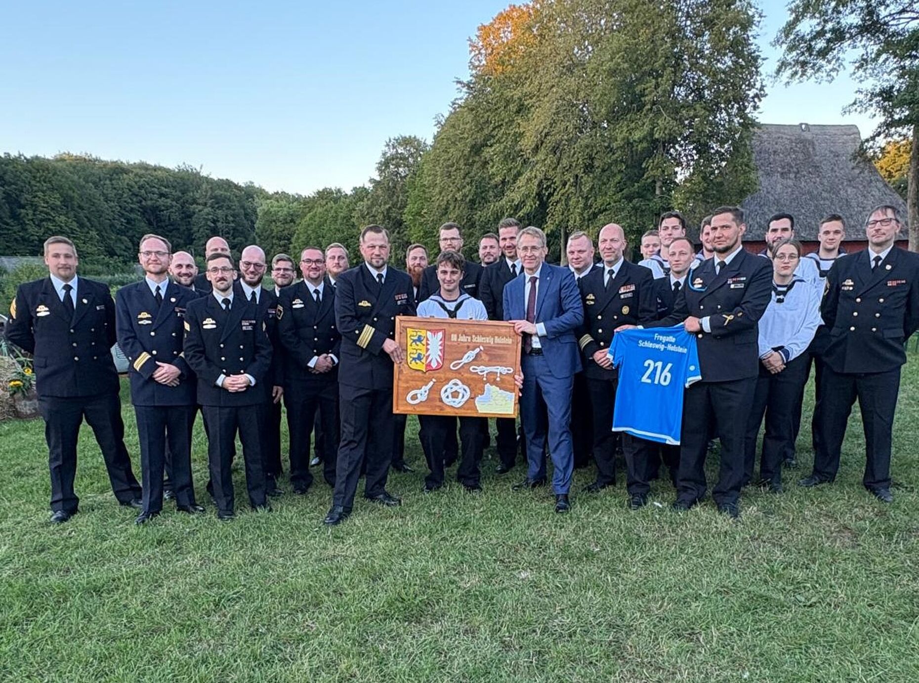 Daniel Günther mit dem Kommandanten der Schleswig-Holstein, Fregattenkapitän Berjan Seifert, und der Besatzung. Foto: DBwV