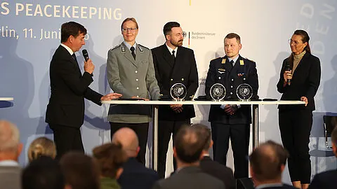 Staatssekretär Sebastian Hartmann (SPD, l.) und die Bundestagsabgeordnete Diana Herbstreuth (CDU, r.) im Gespräch mit den für ihren Einsatz als Peacekeeper geehrten Bundeswehrangehörigen Oberstleutnant Nancy Wübbenhorst, Hauptbootsmann Christopher Thies und Hauptfeldwebel Alexander Ebel (v.l.n.r.). Foto: DBwV/Yann Bombeke