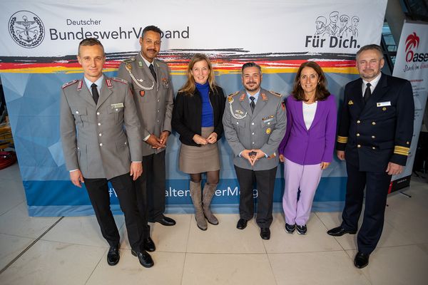 Vor der DBwV-Wand: Marcel Bohnert, Naef Adebahr, Staatssekretärin Siemtje Möller (SPD), Stefan Huss, die Bundestagsabgeordnete Aydan Özoguz und Marco Thiele. Foto: DBwV/Yann Bombeke