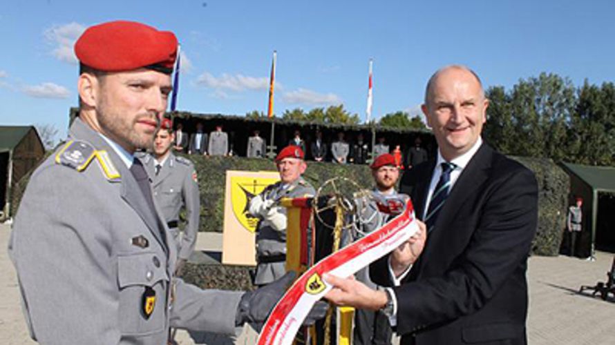 Ministerpräsident Dietmar Woidke (rechts) heftete das Ehrenband an die Bataillonsfahne. Foto: Claudia Marsal, NORDKURIER MEDIENGRUPPE