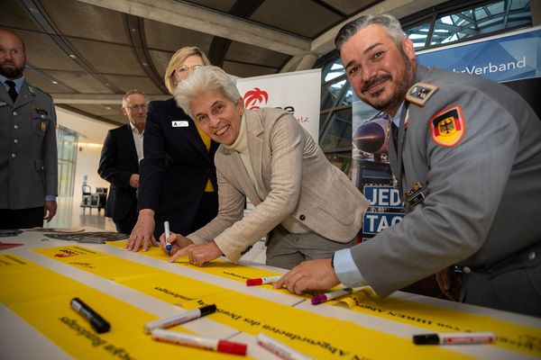 Die Vorsitzende des Verteidigungsausschusses, Marie-Agnes Strack-Zimmermann, signiert ein Gelbes Band. Foto: DBwV/Yann Bombeke