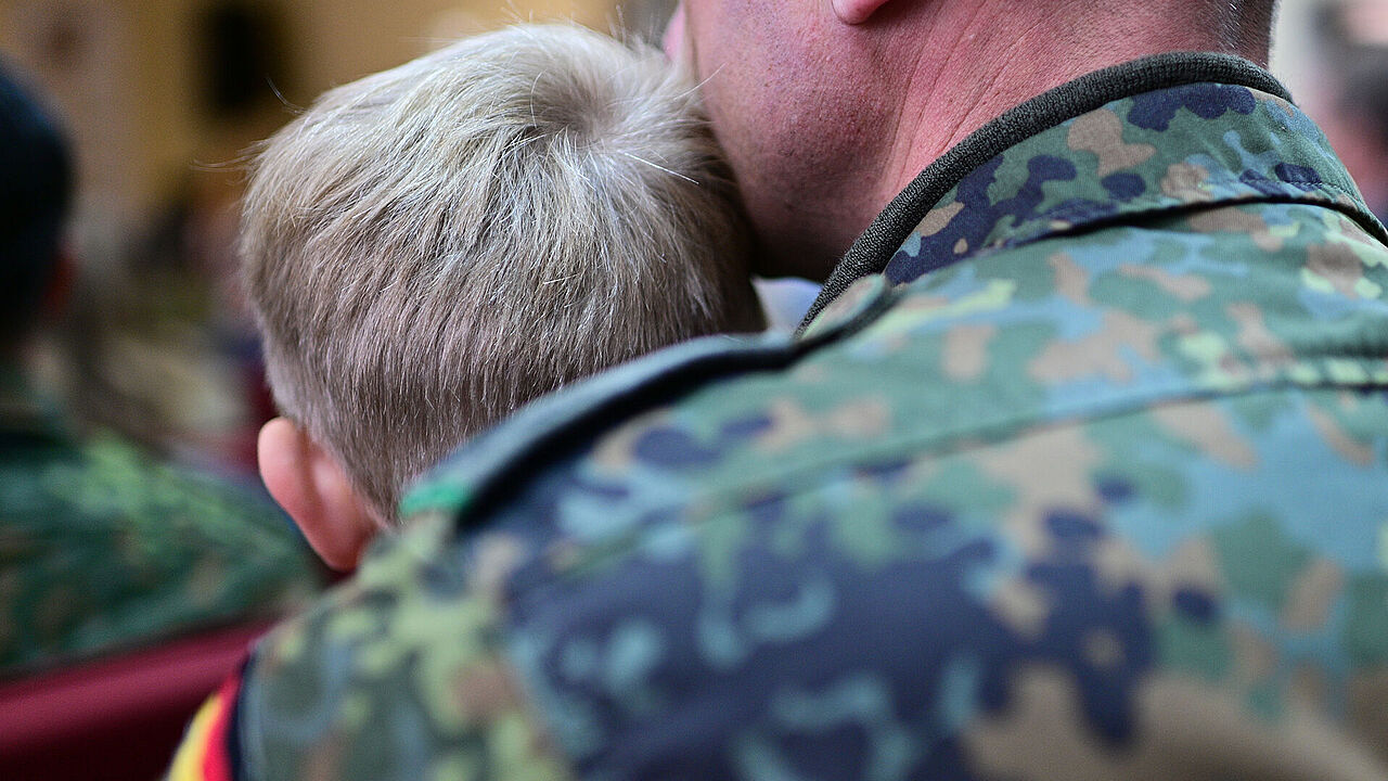 Ein Soldat sitzt während der Eröffnung der Deutschen Schule Vilnius mit seinem Sohn im Publikum. Kinder von Bundeswehrangehörigen im Ausland werden bei der jetzt beschlossenen Frühstartrente nicht berücksichtigt. Foto: picture alliance/dpa/Sebastian Gollnow