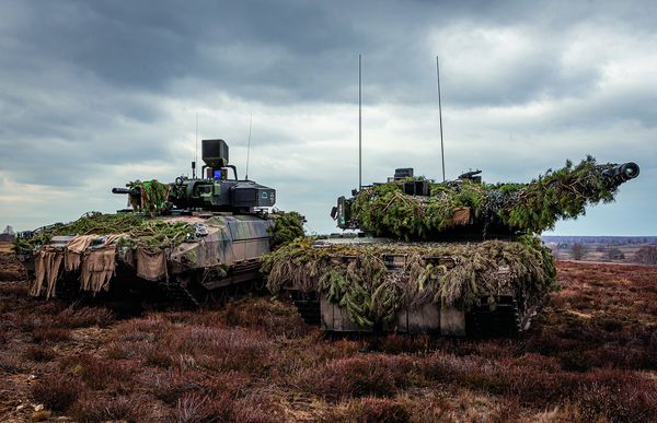 Ein Schützenpanzer Puma und ein Kampfpanzer Leopard 2A7V stehen kampfbereit im Gelände. Foto: Bundeswehr/Mario Bähr