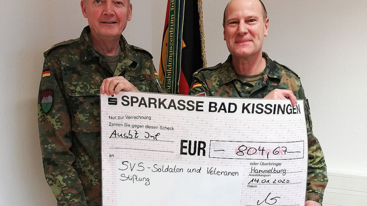 Brigadegeneral Michael Matz bei der Übergabe des symbolischen Spendenschecks an den Bezirksvorsitzenden Oliver Hartmann. Foto: AusbZ Inf