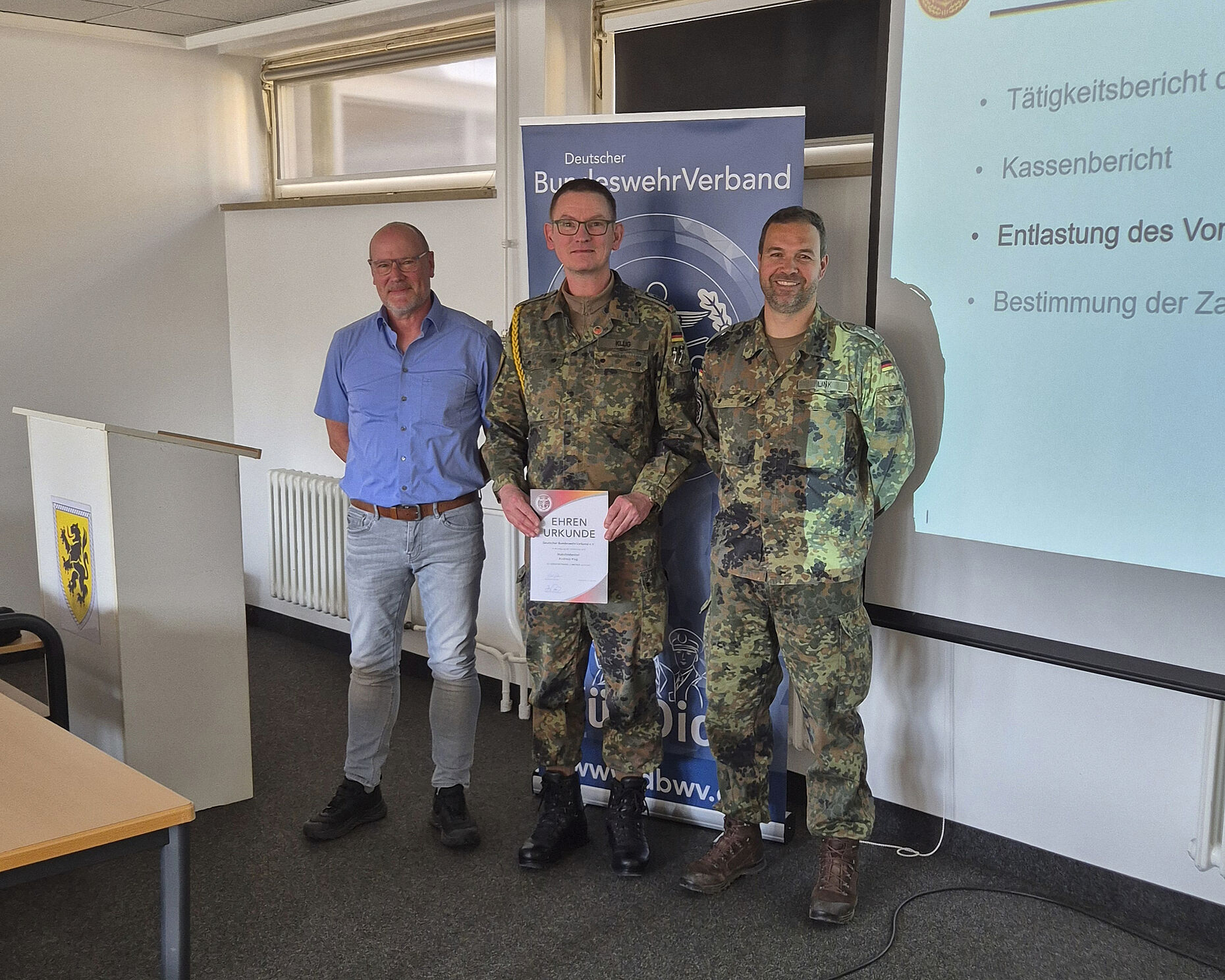 Bezirksvorsitzender Oliver Hartman und StoKa-Vorsitzender Hauptmann Bernd Link zeichnen TruKa-Vorsitzenden Stabsfeldwebel Andreas Klug mit der Verdienstnadel in Bronze aus. Foto: Roland Stengl