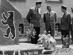 Oberst Karl-Theodor Molinari (links) zeigt dem Regierenden Bürgermeister Berlins, Willy Brandt (2.v.l.), bei seinem Truppenbesuch am 21. Juni 1961 in der Gneisenau-Kaserne in Koblenz den großen Mahnstein mit dem Berliner Wappentier. Foto: DBwV/Archiv