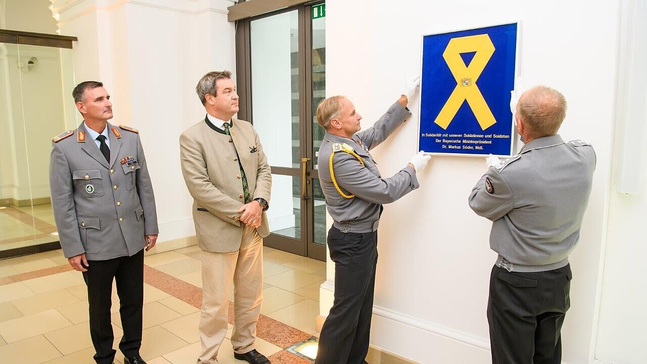 Die Gelbe Schleife wird im Vestibül der Staatskanzlei angebracht.