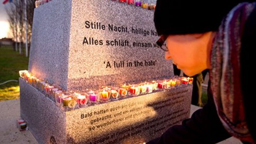 Ein Schüler legt eine Kerze am Denkmal ab, das im belgischen Mesen an den Weihnachtsfrieden von 1914 erinnert. Foto: picture alliance/AP Photo/Virginia Mayo