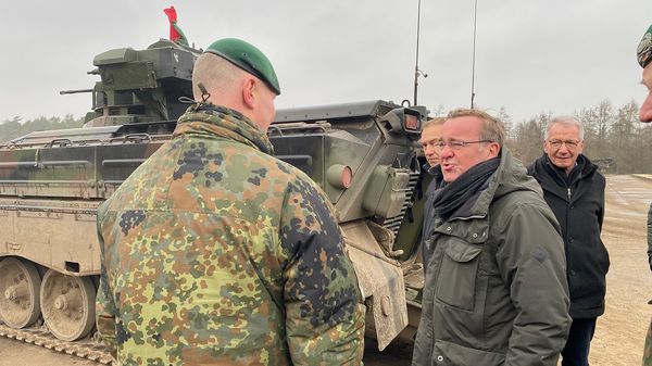 Boris Pistorius (r.) spricht bei seinem Besuch der Panzertruppenschule im niedersächsischen Munster am Schützenpanzer Marder mit einem Ausbilder. Foto: picture alliance/dpa | Carsten Hoffmann 