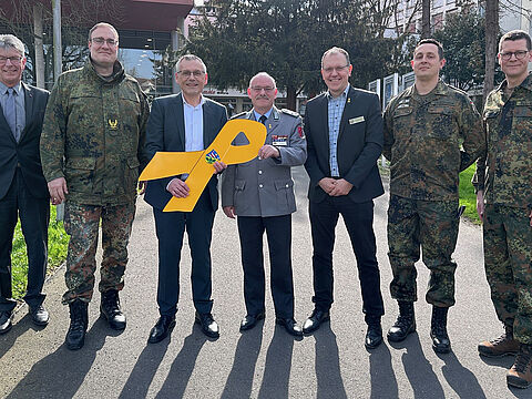 Verleihung der „Gelben Schleife" durch Brigadegeneral Bernd Stöckmann (2.v.l.) und den Landesvorsitzenden West Oberstleutnant Lutz Meier (M.) an Landrat Andreas Siebert (3.v.l.). Mit dabei: Kreistagspräsident Andreas Güttler, Landesgeschäftsführer Carsten Pfenning, Major Michael Leckebusch (Kreisverbindungskommando) und Oberstleutnant Tobias Terhard (Leiter des Heeresmusikkorps Kassel). Foto: Daniel Bettermann / Landkreis Kassel