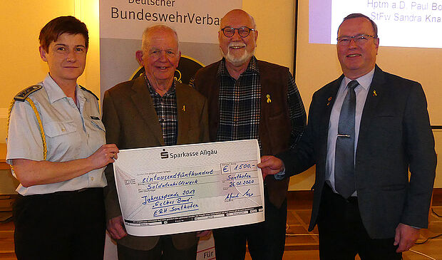 Übergabe des Symbolischen Spendenschecks: Stabsfeldwebel Sandra Knarr (Soldatenhilfswerk, v. l.) durch Hauptmann a.D. Paul Boos (Initiator "Gelbes Band"), Oberstleutnant a.D. Klaus Kanzek (Vorsitzender "Runder Tisch") und Oberstleutnant a.D. Alfred Veit (v.l.). Foto: Rudolf Dürr