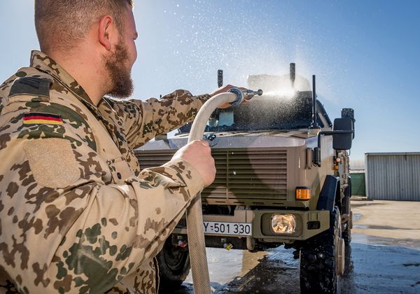 Ein Soldat vom ABC-Abwehrzug reinigt im Camp Marmal ein Fahrzeug vom Typ Dingo für die Rückverlegung nach Deutschland. Foto: Bundeswehr/André Klimke