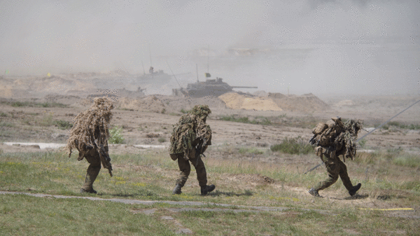 Norwegische Scharfschützen gehen in Position. Im Hintergrund sind CV-90 Schützenpanzer zu sehen. Foto: DBwV/Bombeke