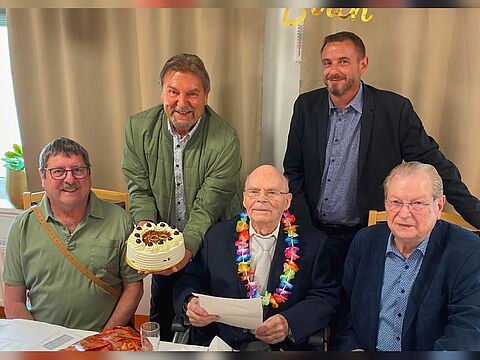 Ein besonderer Moment: Hauptmann a.D. Alfred Hastreiter (Mitte) nimmt voller Freude seine Geburtstagstorte zum 100. Ehrentag entgegen, überreicht vom KERH-Vorsitzenden Michael Lipp (2.v.l.), mit dabei: Alexander Menzel, Leiter des Seniorenzentrums Servatius. Foto: li