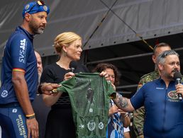 Auf dem Rad fuhren sie über 600 Kilometer nach Berlin: Die Biker der "Tour of Valor". Am Veteranentag übergaben Stefan Huss (rechts, mit Mikro) und Naef Adebahr (2.v.l.) ein Sondertrikot an die Schirmfrau des Veteranentages, Julia Klöckner. Foto: DBwV/Yann Bombeke