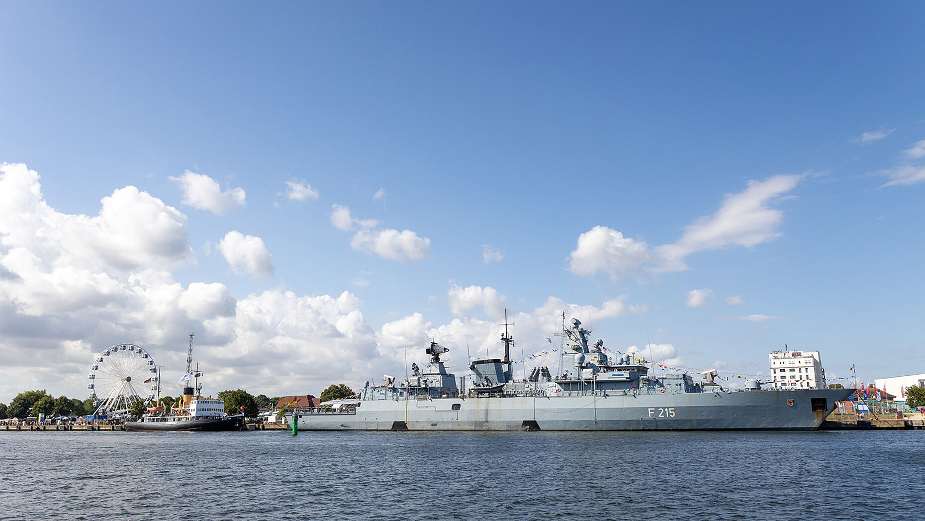 Die Fregatte "Brandenburg" mitten in der Jahrmarkt-Atmosphäre des Rostocker Hafens - das ist die Hanse Sail. Foto: DBwV/Yann Bombeke